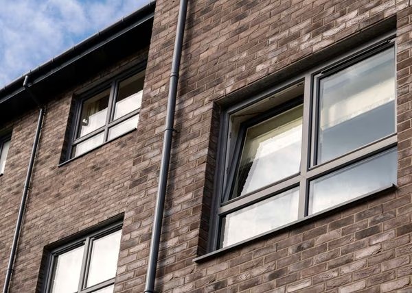 Grey tilt and turn windows on a brick house